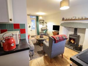 a kitchen and living room with a wood stove at 1 Llwyn Hir in Blaenau-Ffestiniog