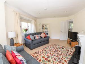 a living room with a couch and a television at Brunton Lodge in Bowness-on-Windermere