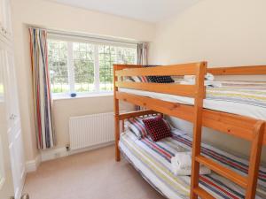 a bedroom with two bunk beds and a window at Brunton Lodge in Bowness-on-Windermere