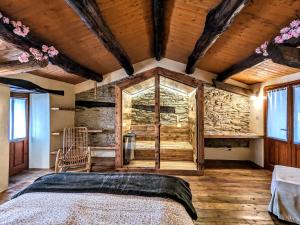 Paesana的住宿－Casa Nenella，一间带一张床的卧室,位于带木制天花板的房间内