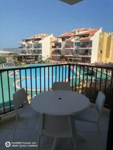 una mesa blanca y sillas en un balcón con piscina en Solaren Apartments Boavista en Sal Rei