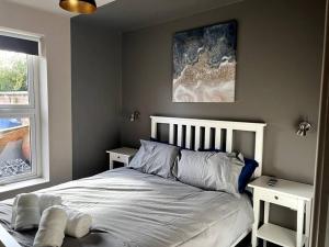 um quarto com uma cama com duas mesas de cabeceira ao lado de uma janela em University Apartment • Sleeps 8 em Loughborough