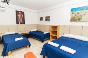 a room with two beds with blue sheets at Huanchaco Paradise Hotel in Huanchaco