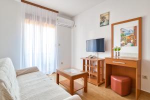 a living room with a couch and a tv at Garni Hotel Milica in Herceg-Novi