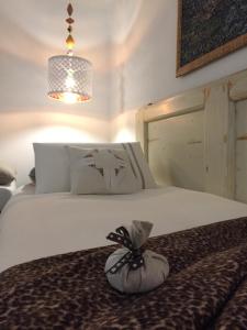 1 dormitorio con 1 cama blanca grande con lámpara de araña en A casa di Esther en Bolonia