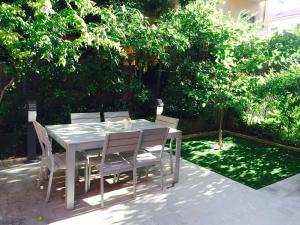 una mesa blanca y sillas en un jardín en A casa di Esther en Bolonia