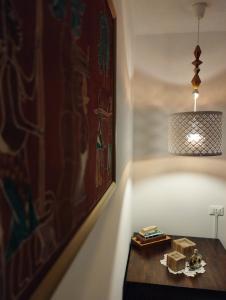 ボローニャにあるA casa di Estherの絵画とランプが飾られた部屋のテーブル
