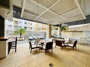 a dining room with tables and chairs in a building at Mediterrâneo 507 - Todo Equipado, Ar Condicionado, Churrasqueira na Varanda, Internet Fibra 600MB, Estacionamento Grátis in Cabo Frio