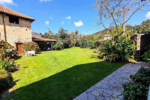 un patio con un camino de piedra y una casa en Casa vacacional Carmen, en Rales