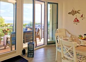 a living room with a table and chairs and a balcony at Baabe Villen Ensemble FeWo 12 Meer in Baabe