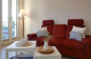 a living room with a red couch and a table at Baabe Villen Ensemble FeWo 12 Meer in Baabe