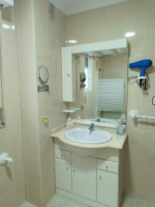 a bathroom with a sink and a mirror at PISO EN 2* LINEA DE PLAYA in Barbate