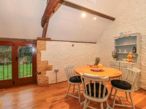 cocina con mesa de madera y sillas en The Old Granary, en Beaminster