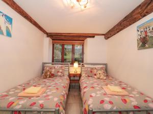 two twin beds in a room with a window at The Old Granary in Beaminster
