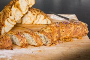 una hogaza de pan en una tabla de cortar con un poco de pan en B&B Can Jan, en Sant Ferriol