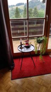 une table sur un tapis rouge devant une fenêtre dans l'établissement MountainLodge, à Altenau