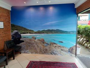 a wall mural of a beach with rocks at Acrópolis Marina Hotel in Angra dos Reis +26 photos