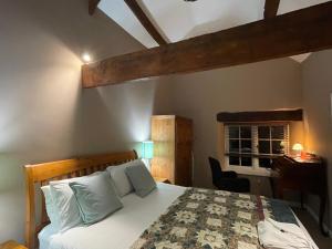 a bedroom with a bed and a desk in a room at Northover Manor Hotel in Ilchester