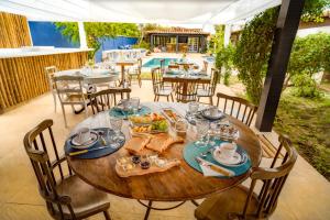 ein Holztisch mit Essen darauf auf einer Terrasse in der Unterkunft Pousada Maré Búzios in Búzios + 38 Fotos