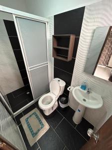 a small bathroom with a toilet and a sink at Hotel SG in Doradal