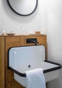 Hotel Mont-Tremblant في مونت تريمبلانت: حوض الحمام مع مرآة ومنشفة