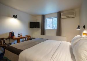 a hotel room with a large bed and a television at Hotel Mont-Tremblant in Mont-Tremblant