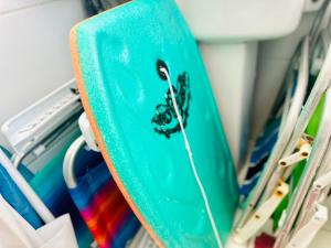 a green surfboard on a rack with other surfboards at Mediterrâneo 507 - Todo Equipado, Ar Condicionado, Churrasqueira na Varanda, Internet Fibra 600MB, Estacionamento Grátis in Cabo Frio