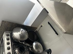 a kitchen with pots and pans on a stove at Mediterrâneo 507 - Todo Equipado, Ar Condicionado, Churrasqueira na Varanda, Internet Fibra 600MB, Estacionamento Grátis in Cabo Frio