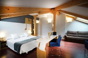 una camera da letto con un letto, una scrivania e un divano di Hotel El Coloquio a Valladolid