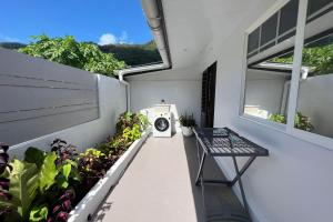 uma varanda com uma máquina de lavar roupa numa casa em Fare Tokatea - Charming Studio w Excl Beach em Iumaru