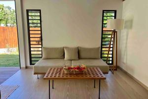a living room with a couch and a table at Villa Māha Iti 1 - Little Villa w Private Pool in Papetoai +10 photos