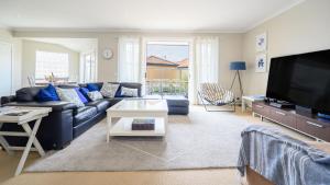 uma sala de estar com um sofá azul e uma televisão em Sandpiper 9 - Close to Town and Beach em Inverloch