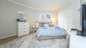 a bedroom with a bed with a mirror and a dresser at Sandpiper 9 - Close to Town and Beach in Inverloch