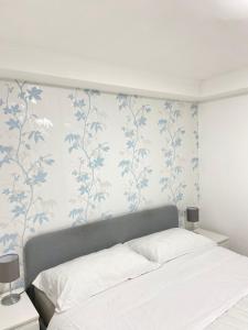 um quarto com uma cama com papel de parede azul e branco em DioNilo 30 em Nápoles