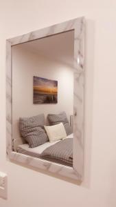 uno specchio su un muro con un divano di Pension Hammer a Mensfelden