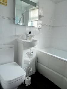 a white bathroom with a sink and a toilet and a tub at Kara Mia in Boston