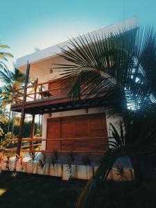 uma casa com uma palmeira em frente em Bangalô Patuá em Barra Grande