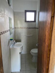 a bathroom with a toilet and a sink and a window at Hui-na in Ushuaia