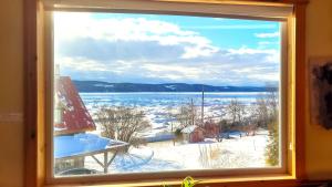 a window with a view of a snow covered field at La vieille ferme, Écogîte in Saint-Fulgence