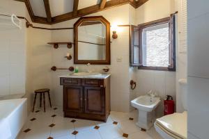 un bagno con lavandino, WC e specchio di Casa vacacional Dario a Rales Altre 37 foto