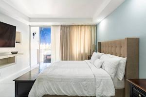um quarto com uma grande cama branca e uma janela em City Edge La Vie em Kingston