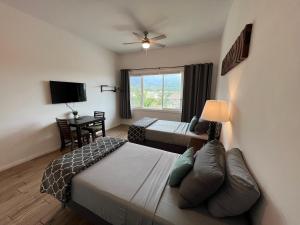 a hotel room with two beds and a window at Unit 7 Maui Ohana Modern Studio in Wailuku