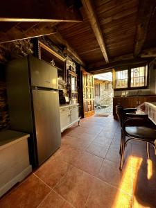 cocina con nevera, mesa y sillas en Casa Folibar - Desconexión en plena naturaleza - Valle del Silencio, en Manzanedo de Valdueza