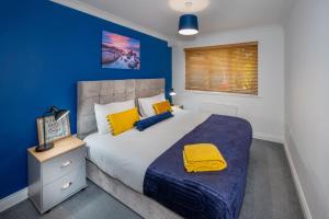 um quarto com uma cama grande e uma parede azul em Scarlet Oaks, easy walk from Hospital em Frimley