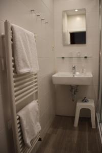 a white bathroom with a sink and a mirror at Haus Alexander in Heringsdorf