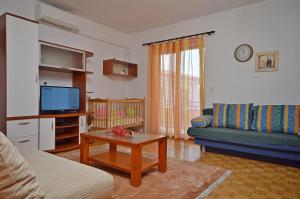 a living room with a couch and a tv at Apartment and Room Ivica in Vodice
