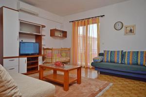 un soggiorno con divano e TV di Apartment and Room Ivica a Vodice