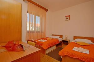 a hotel room with two beds and a window at Apartment and Room Ivica in Vodice +37 photos