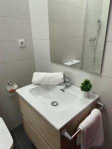 La salle de bains est pourvue d'un lavabo et d'un miroir. dans l'établissement Hostel & Rooms O Albergue da Meiga, à Padrón
