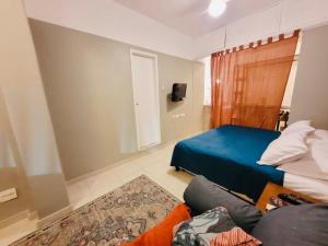 1 dormitorio con cama, sofá y TV en Estúdio completo entre Copacabana e Ipanema em frente ao metro a 300 metros da praia, en Río de Janeiro